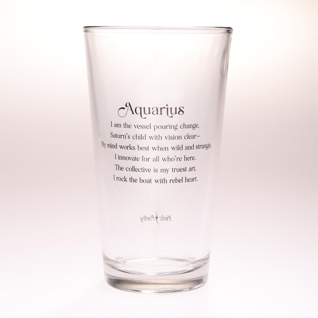 A clear glass drinking tumbler with black printed text reading 'Aquarius' and a poem associated with the Aquarius zodiac sign, shown on a plain light background.