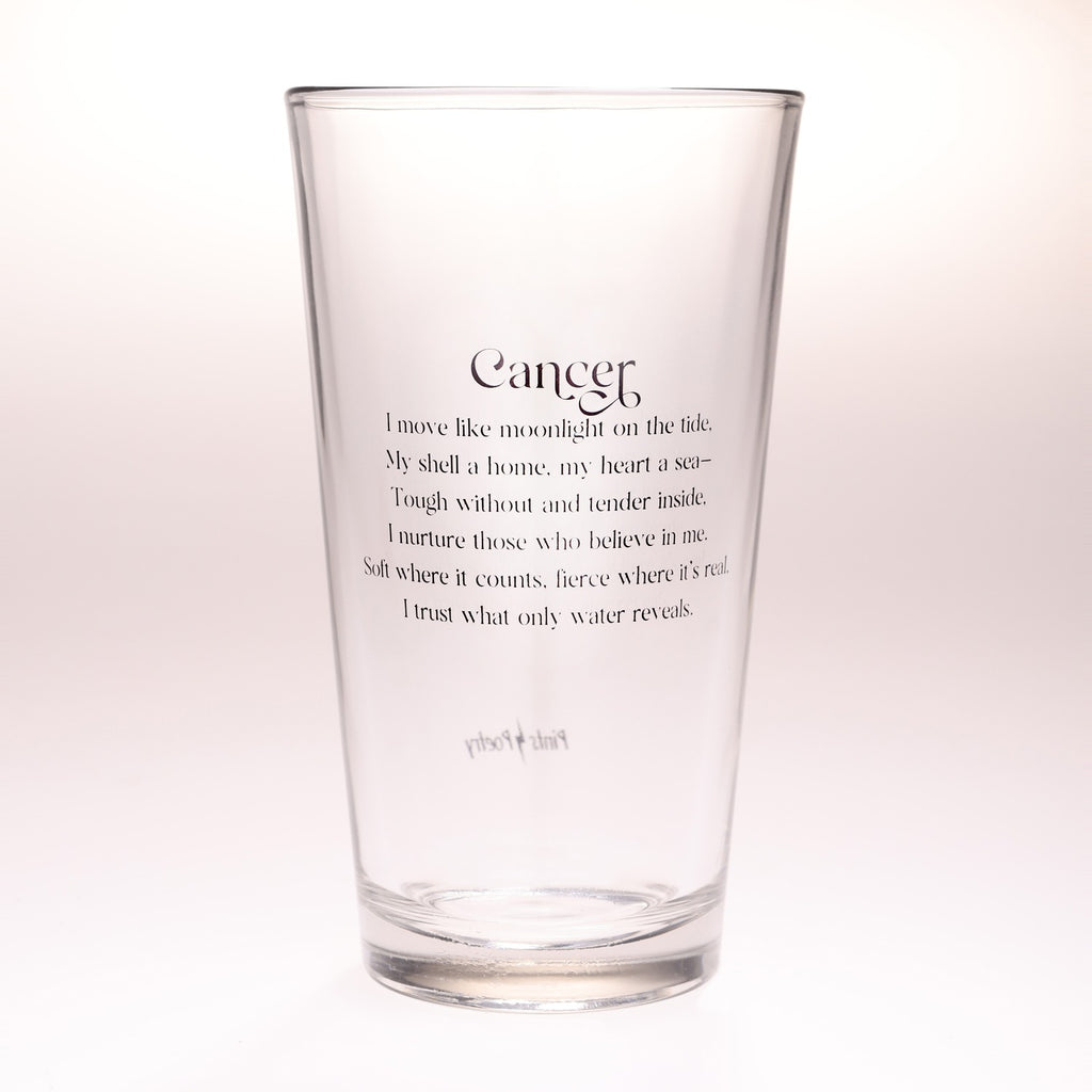 A clear glass pint glass with black printed text on a white background. The text features a poem titled 'Cancer' with a quote about moonlight on the tide and a shell.