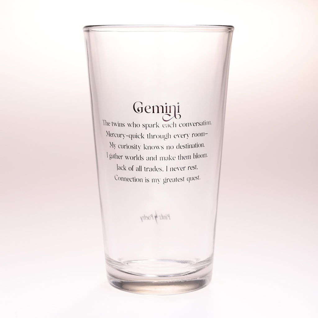 A clear glass pint glass with black printed Gemini zodiac text on the front, photographed against a clean white background.