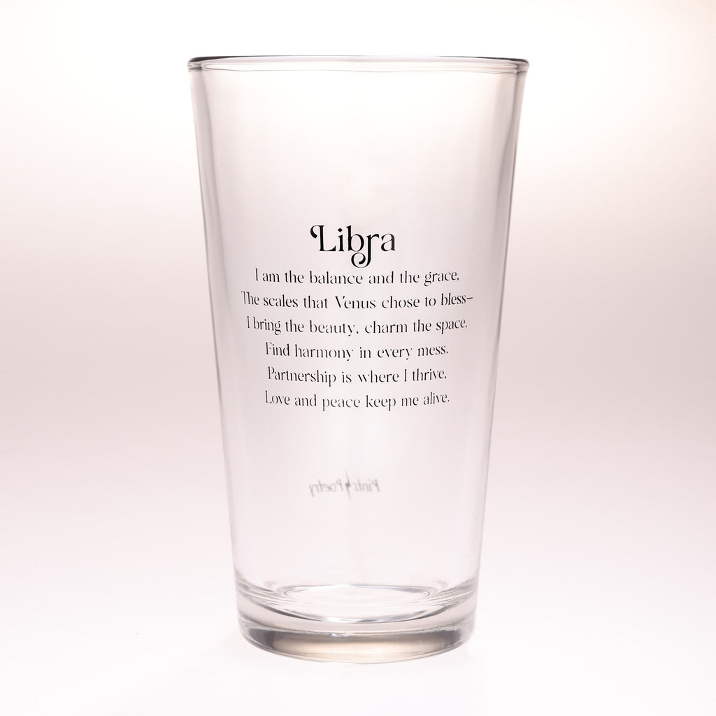 A clear glass drinking tumbler with black printed text on a white background. The text reads 'Libra' followed by a poem describing Libra traits, and the brand name 'Pints and Poetry' is printed near the bottom.