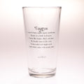 A clear glass drinking tumbler with black printed text reading 'Taurus' and a poem about the zodiac sign, photographed against a plain light background.