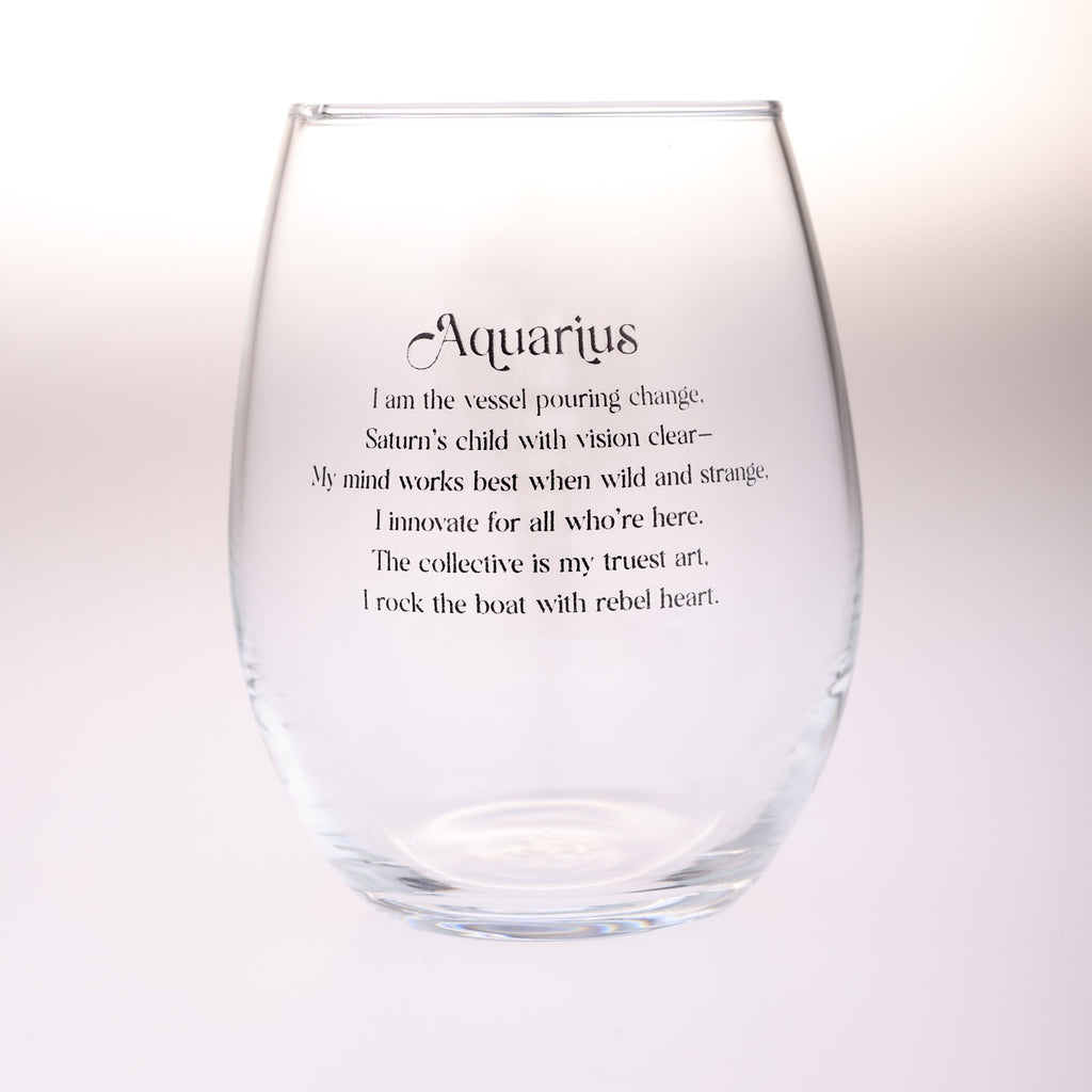 A clear stemless wine glass with black printed text reading 'Aquarius' and a poem associated with Aquarius, shown on a soft white background.