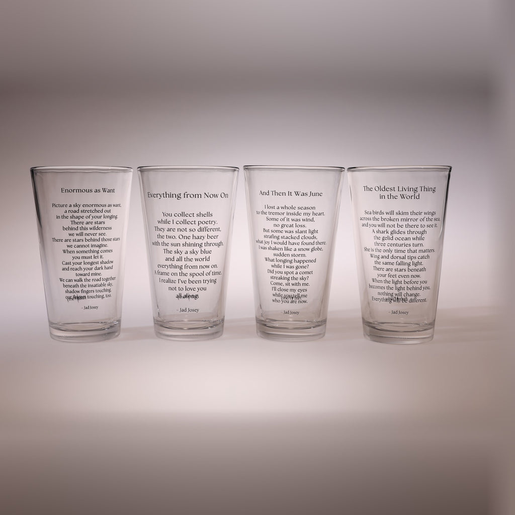 Four clear drinking glasses lined up side by side, each printed with a different poem in black text, set against a neutral gray background.