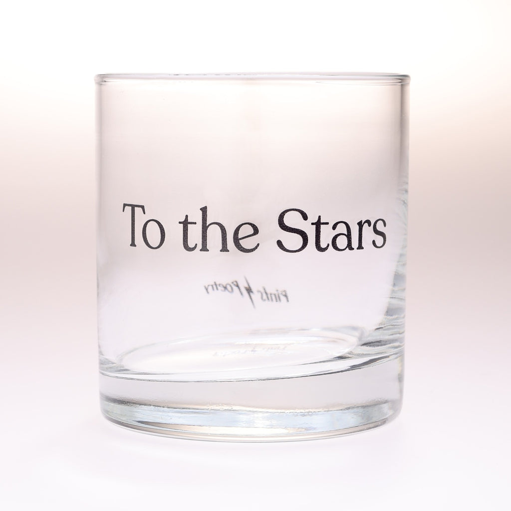 A rocks glass tumbler with the words 'To the Stars' printed in black serif font on the front set against a clean white background.