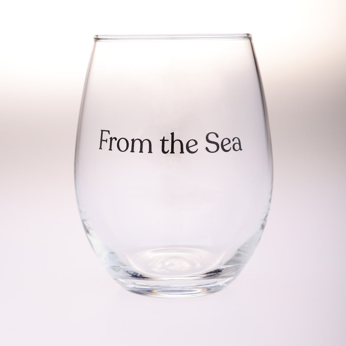 A clear stemless wine glass with the text 'From the Sea' printed in black serif font on the front, set against a clean white background.